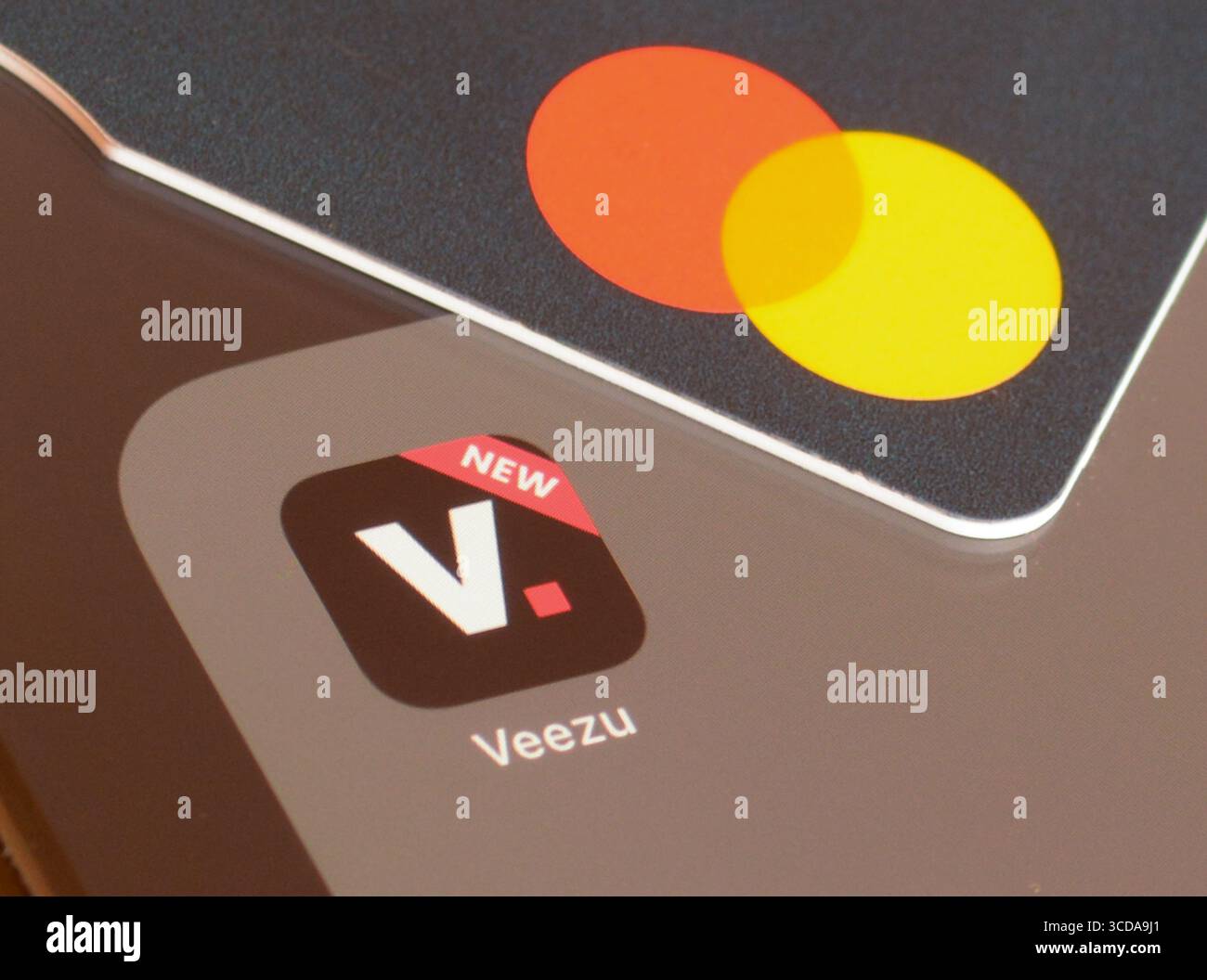 Veezu Taxi App auf Smartphone-Bildschirm mit Mastercard zur Zahlung Stockfoto