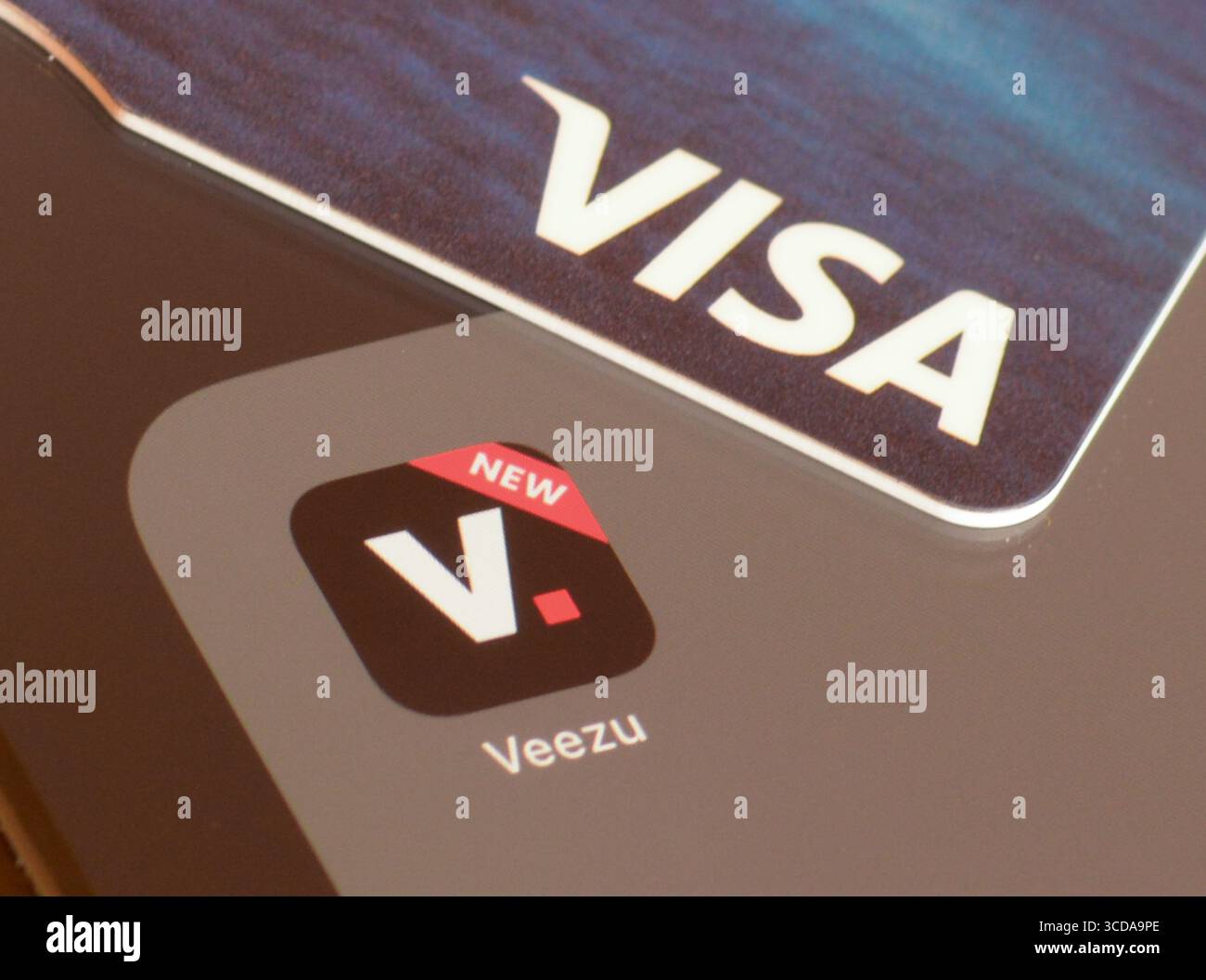 Veezu Taxi App auf Smartphone-Bildschirm mit VISA-Karte zur Zahlung Stockfoto