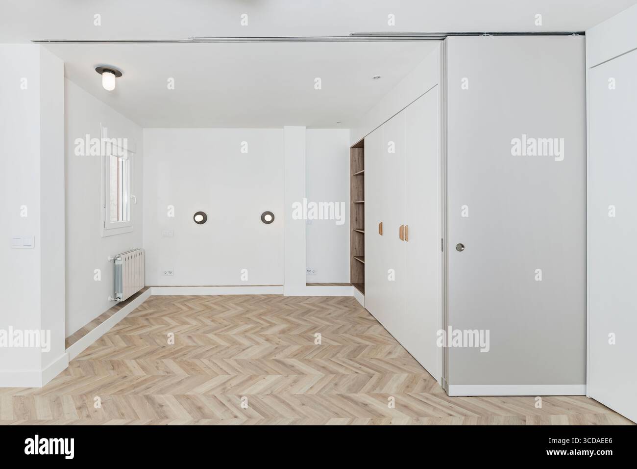 Boutique-Hotelzimmer mit eingebautem Wandschrank und indirekter Beleuchtung für eine komfortable Atmosphäre Stockfoto