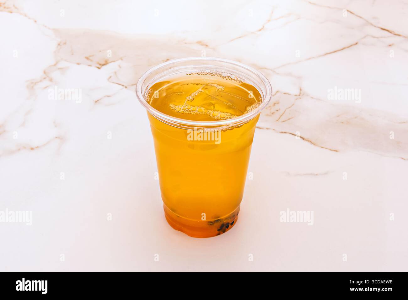 Sommer-Klassiker: Frisch gebrühter Eistee mit einem Hauch Honig, serviert in einem mattierten Glas mit Kondensationsüberzug, das zum Schlucken einlädt Stockfoto