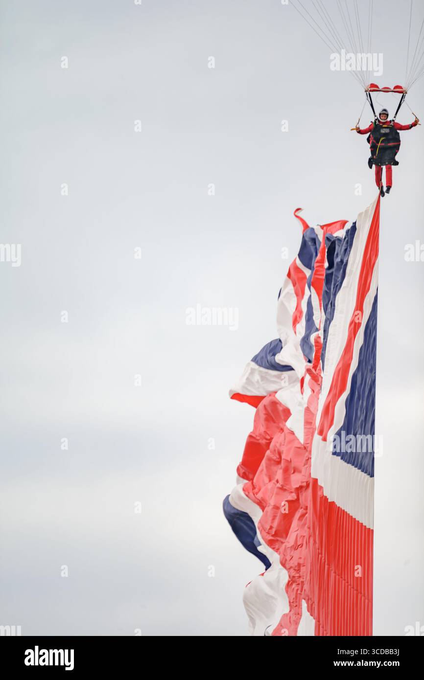 Blackpool, England - 10. August 2025: Ein Mitglied der Red Devils, der Fallschirmspringer des britischen Fallschirmregiments, springt mit einer Flagge auf der Stockfoto