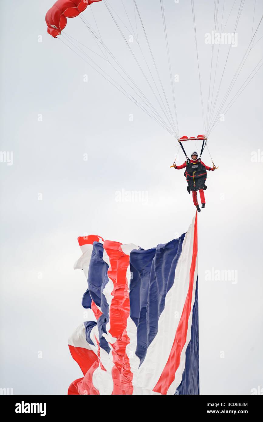 Blackpool, England - 10. August 2025: Ein Mitglied der Red Devils, der Fallschirmspringer des britischen Fallschirmregiments, springt mit einer Flagge auf der Stockfoto