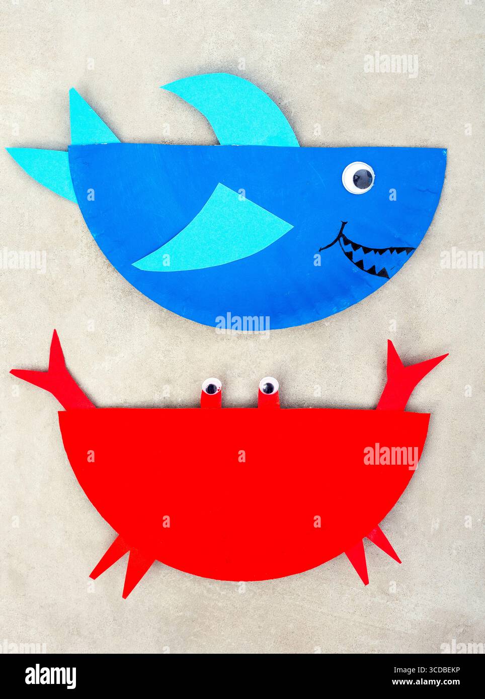 Zwei Hälften Papierteller bemalt, um einen Hai und eine Krabbe zu machen Stockfoto