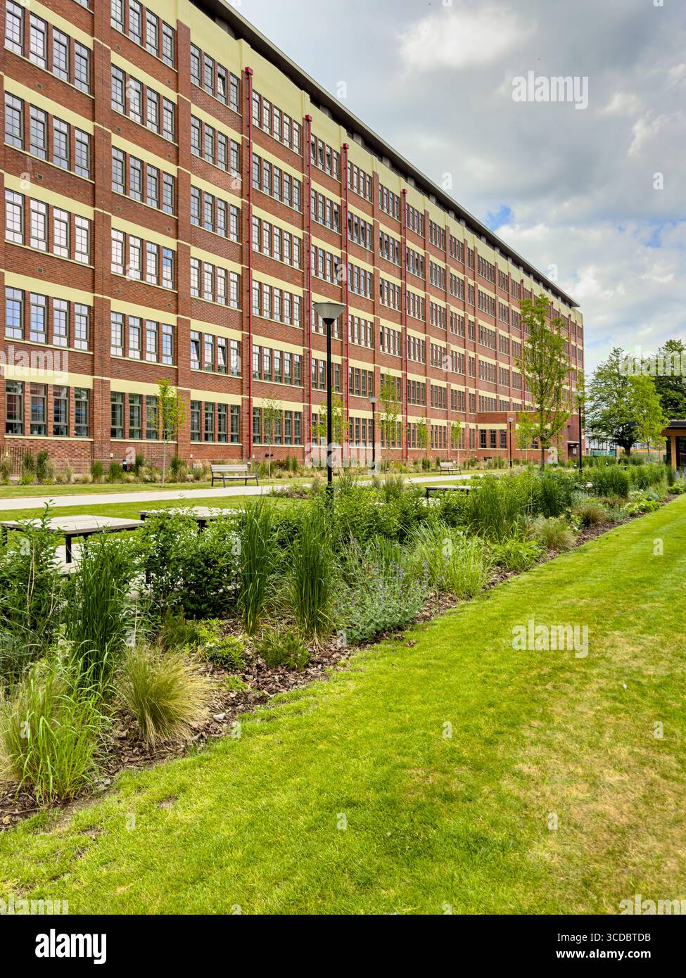 Die Cocoa Works Apartments, eine restaurierte ehemalige Schokoladenfabrik von Rowntree in York, mit rotem Ziegelstein, großen Industriefenstern und einer Landschaftsgestaltung Stockfoto