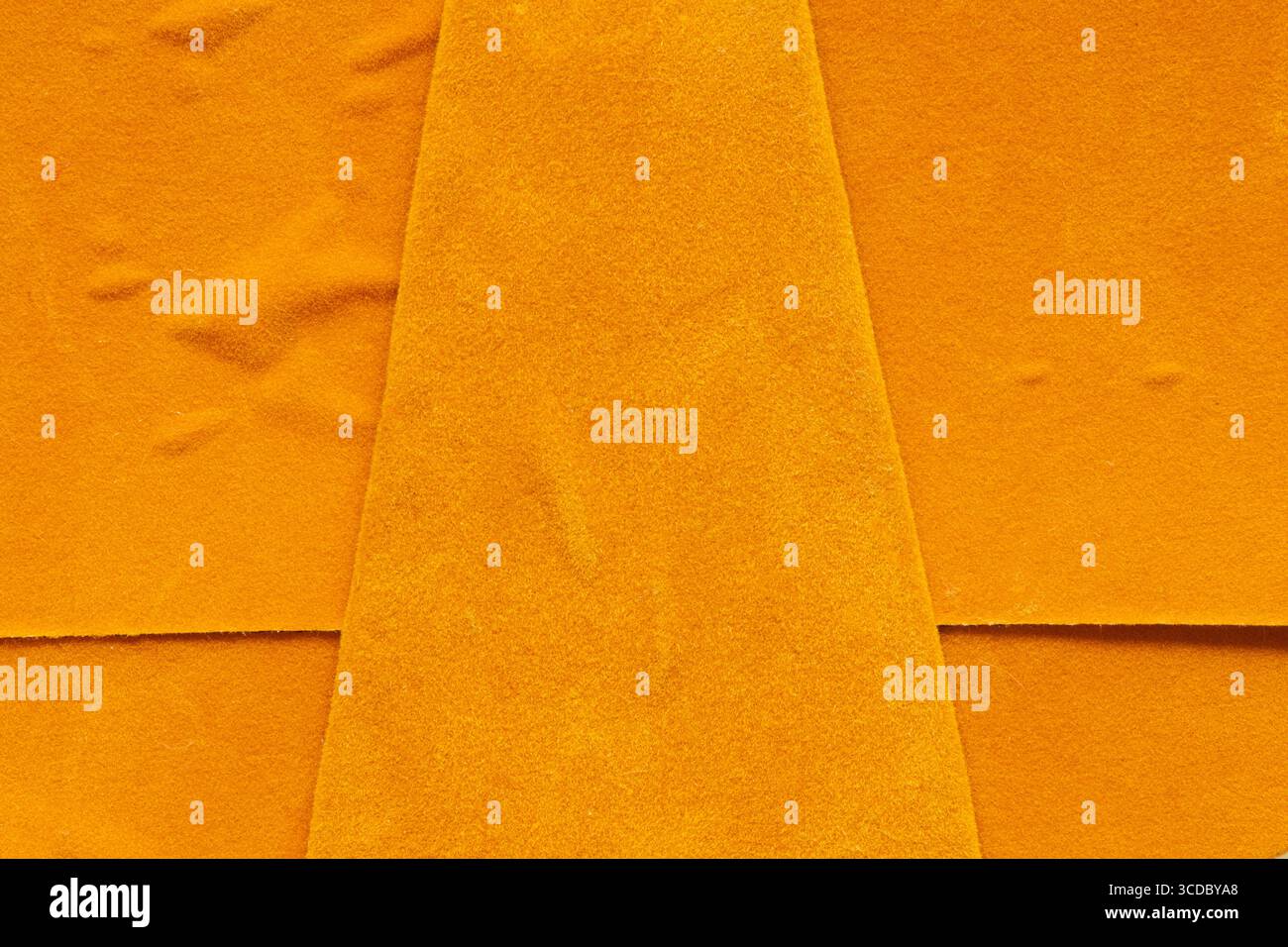 Nahaufnahme aus orangefarbenem Wildleder mit unebener Oberfläche und Falten, Textur für Hintergrund oder Tapete Stockfoto