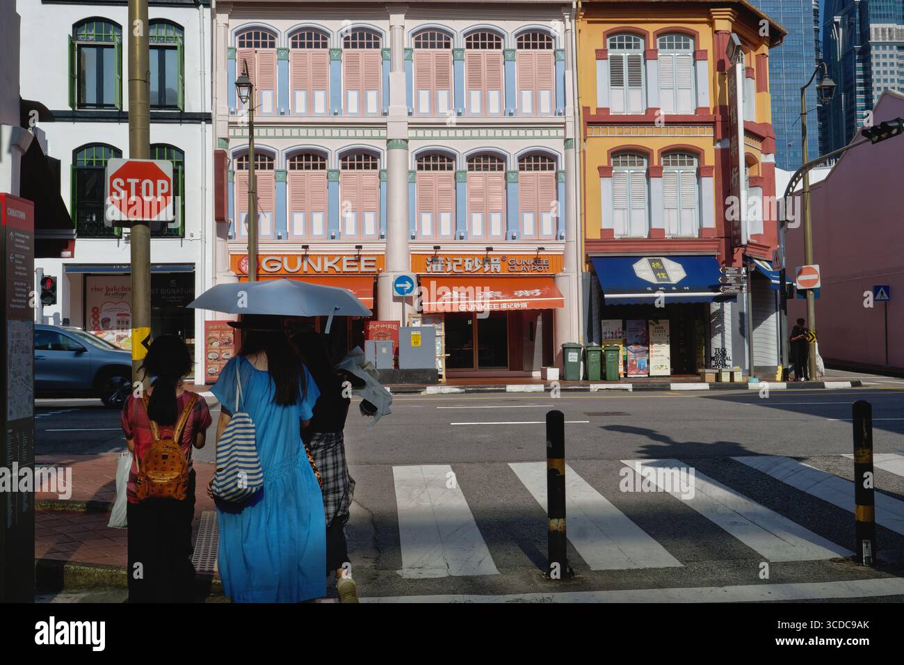 Asiatische Touristen in Smith St., Chinatown, Singapur, die in Richtung South Bridge Rd. Schauen Und ein attraktives, dreistöckiges traditionelles altes Ladenlokal Stockfoto