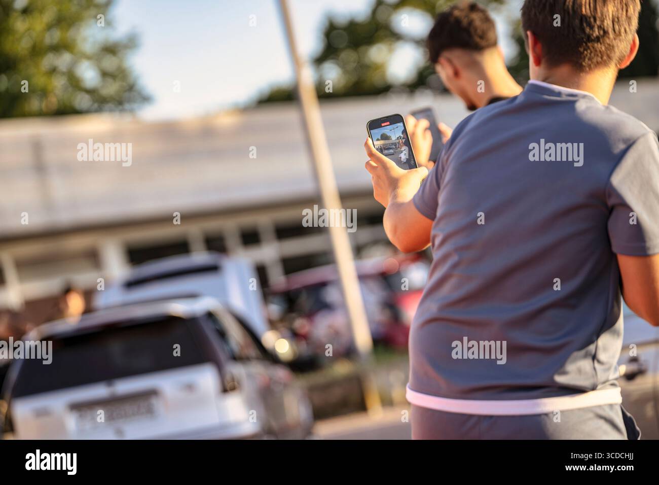 Rom, italien 18. juli 2025 nehmen zwei Motorsportfans mit ihrem Smartphone Videos eines Autorennen auf und halten die spannenden Momente des stan fest Stockfoto