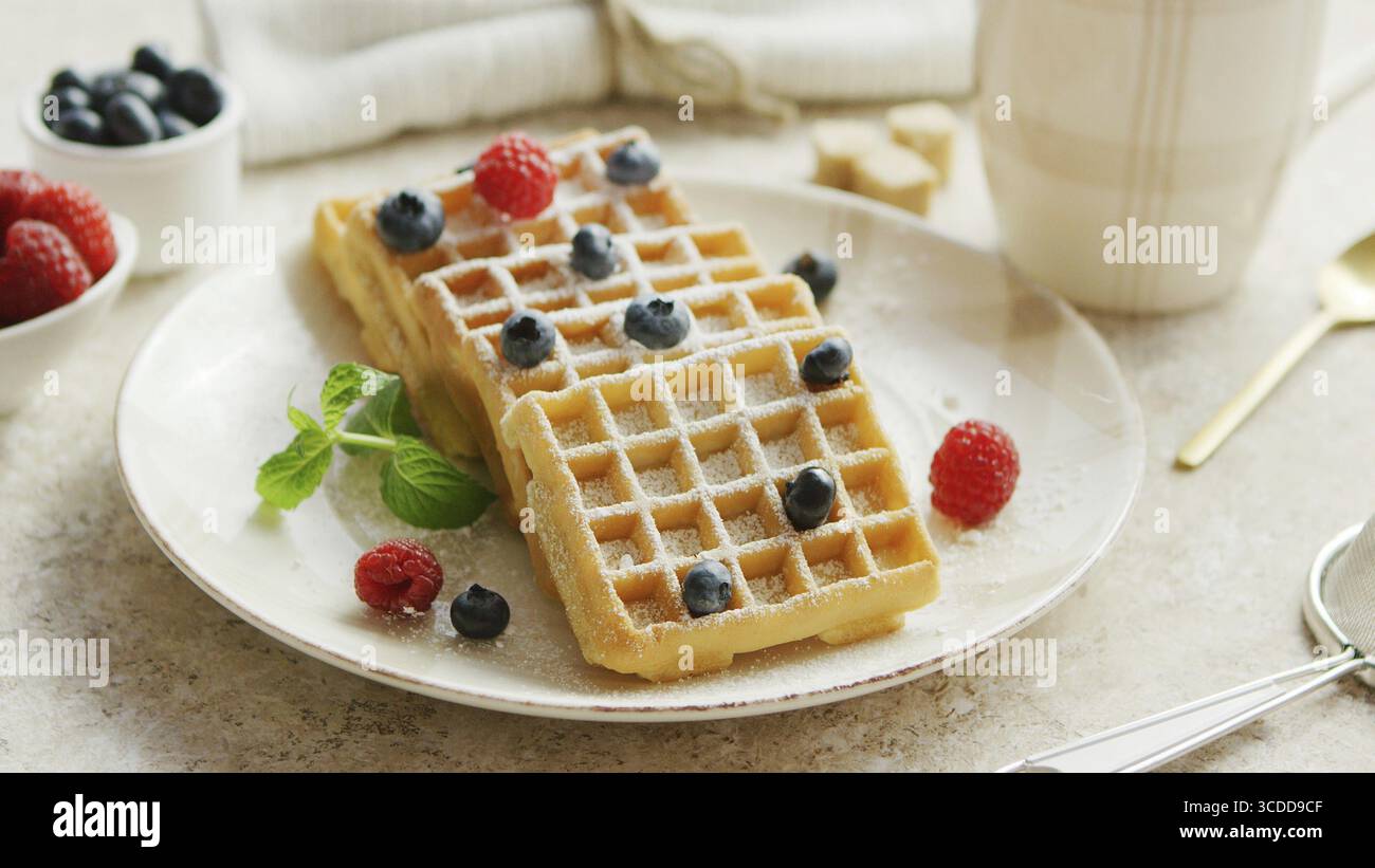 Closeup Schuß aus Keramik Teller mit leckeren weichen Waffeln und reife Beeren stehen auf Marmor Tischplatte Stockfoto