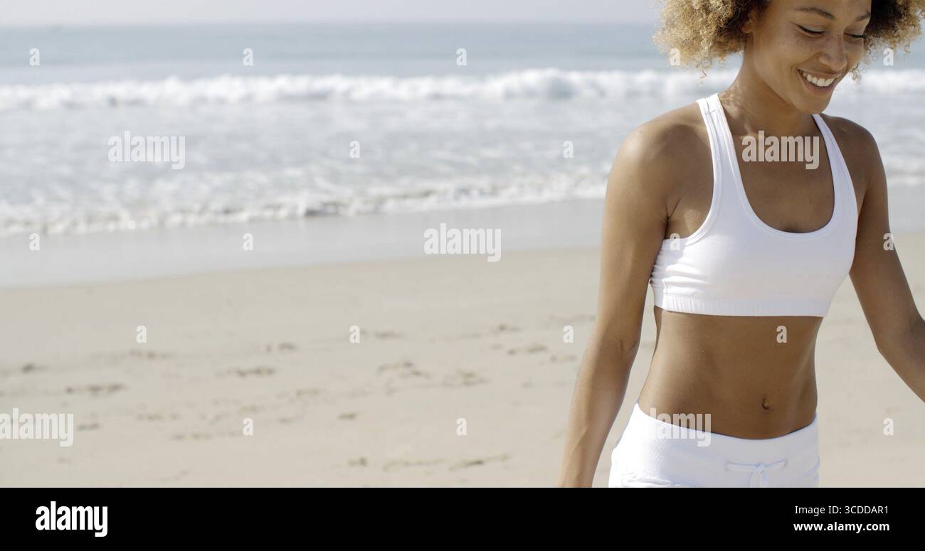 Afroamerikanische Frau Sportswear gehen vom Meer entfernt in Zeitlupe Stockfoto