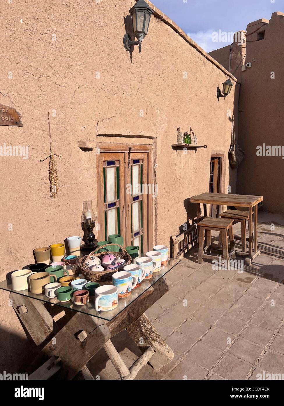 Rustikale Innenhofecke im Honar Café, Yazd, mit handgefertigten Tassen, Holztischen und ziegelwänden. Stockfoto Rustikale Innenhofecke im Honar Café, Yazd, mit handgefertigten Tassen, Holztischen und ziegelwänden. Stockfoto