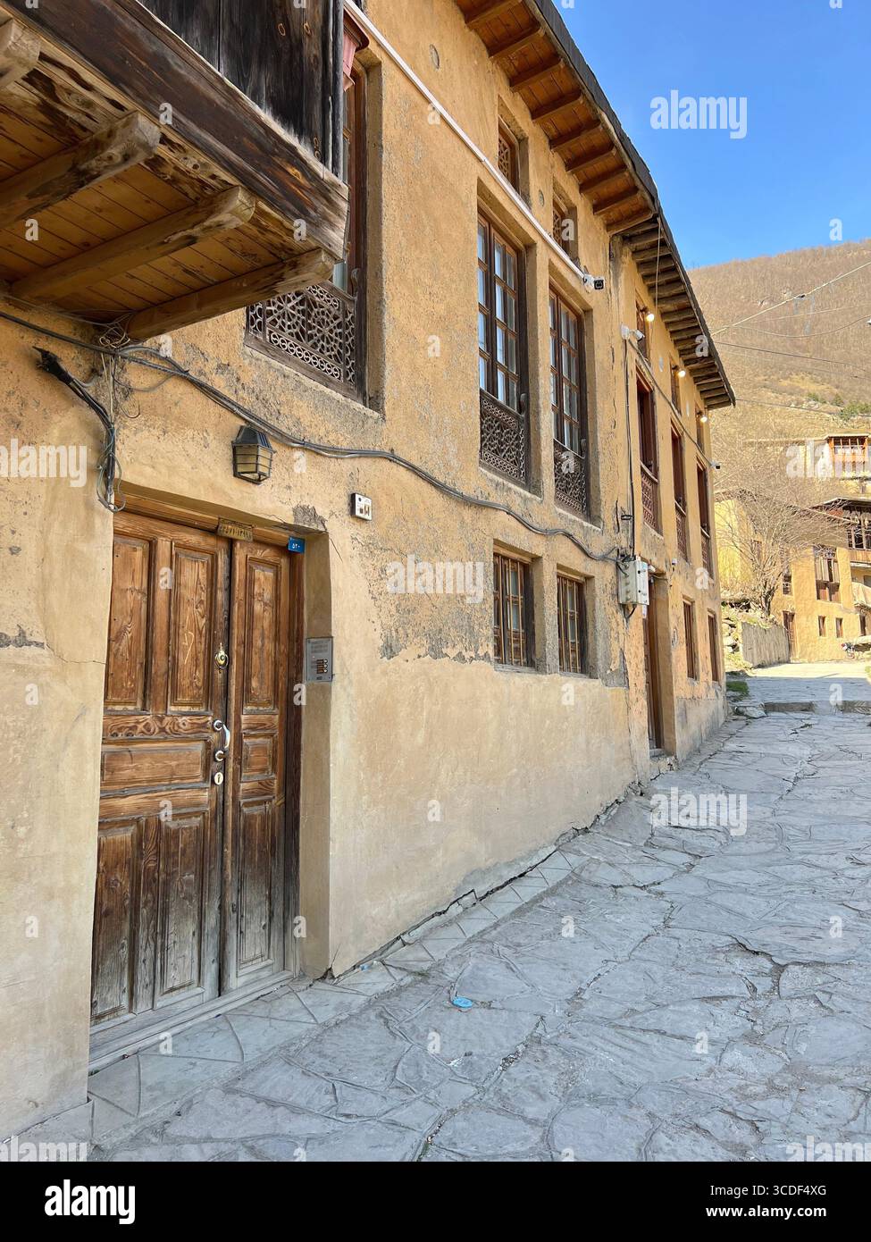 Traditionelles Lehmziegelhaus mit Holzbalkon in Masuleh, Irans historischem Treppendorf. Stockfoto Traditionelles Lehmziegelhaus mit Holzbalkon in Masuleh, Irans historischem Treppendorf. Stockfoto
