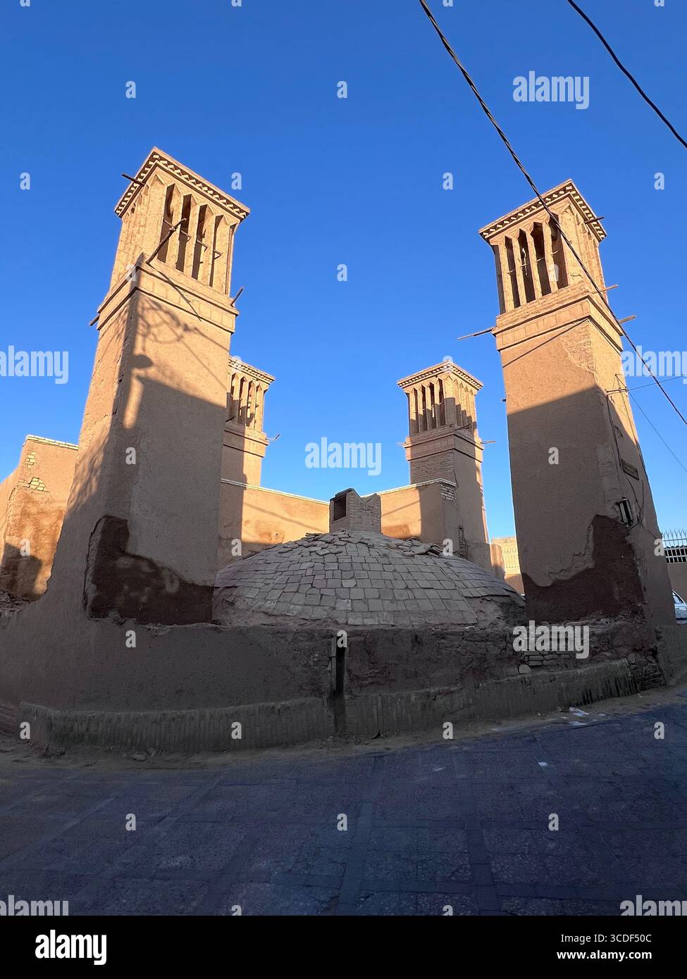 Vier alte Windfänger stehen hoch in Yazd, Iran, die den persischen Einfallsreichtum in der abkühlenden Architektur der Wüste symbolisieren. Stockfoto Vier alte Windfänger stehen hoch in Yazd, Iran, die den persischen Einfallsreichtum in der abkühlenden Architektur der Wüste symbolisieren. Stockfoto