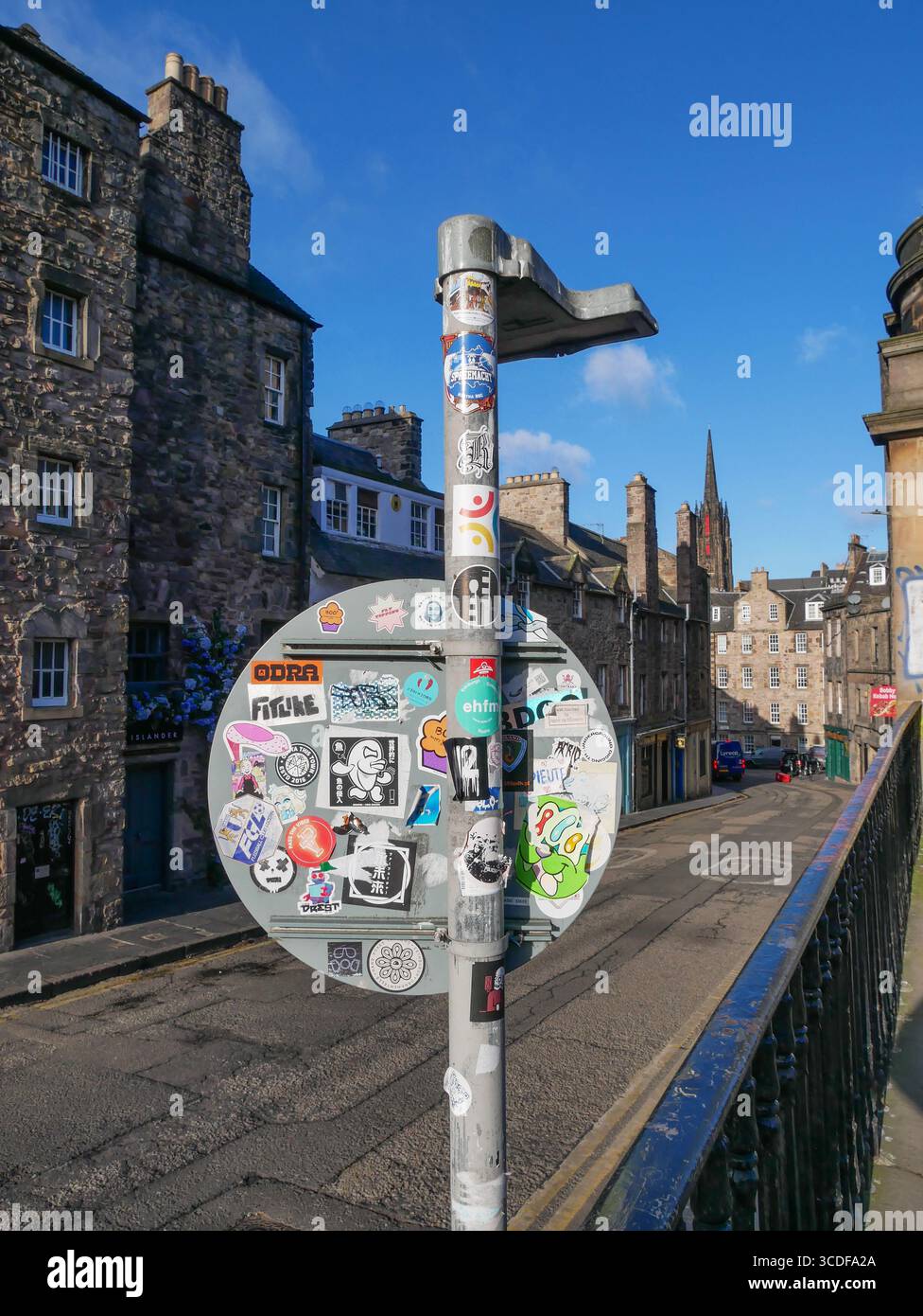 Aufkleber auf der Rückseite eines Straßenschilds und alte Steinterrassenhäuser auf der Candlemaker Row in der Altstadt von Edinburgh in Schottland, Großbritannien Stockfoto