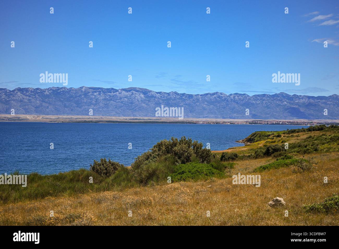 Malerische Aussicht auf die velebit-Berge auf der anderen Seite des Meeres von der Insel pag, kroatien, die die natürliche Schönheit der adriaküste zeigt. Stockfoto