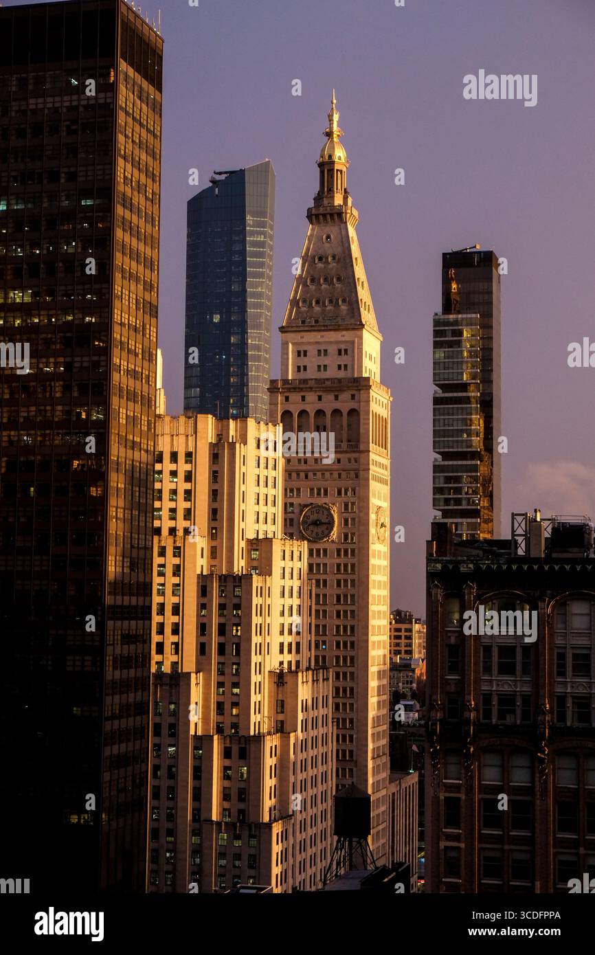 New York City, New York, USA. Sonnenuntergang über Wolkenkratzern einschließlich des Met Life Gebäudes mit einem violetten Himmel. Stockfoto