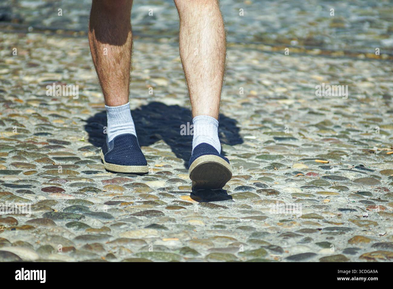 Touristen schlendern durch die charmante Altstadt, tragen atmungsaktive Schuhe, Nahaufnahme. Authentisches Reiserlebnis, langsamer Tourismus und kulturelle Entdeckungen Stockfoto