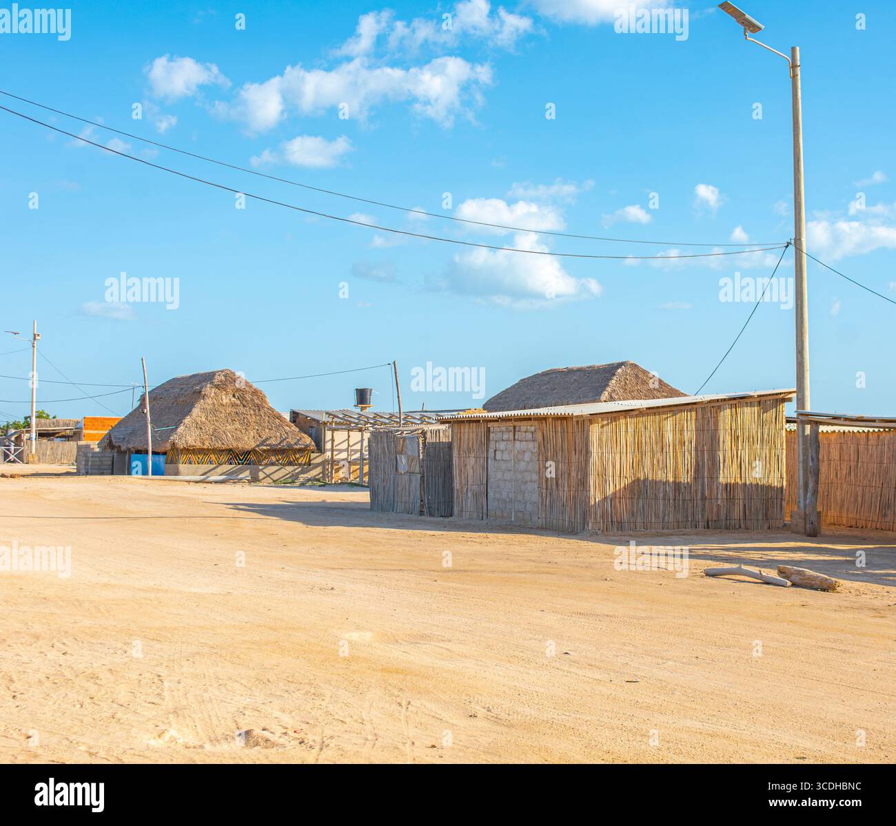 Ein malerischer Blick auf traditionelle Hütten in Cabo de la Vela, La Guajira, mit Blick auf die Wüstenlandschaft und den klaren Himmel. Stockfoto