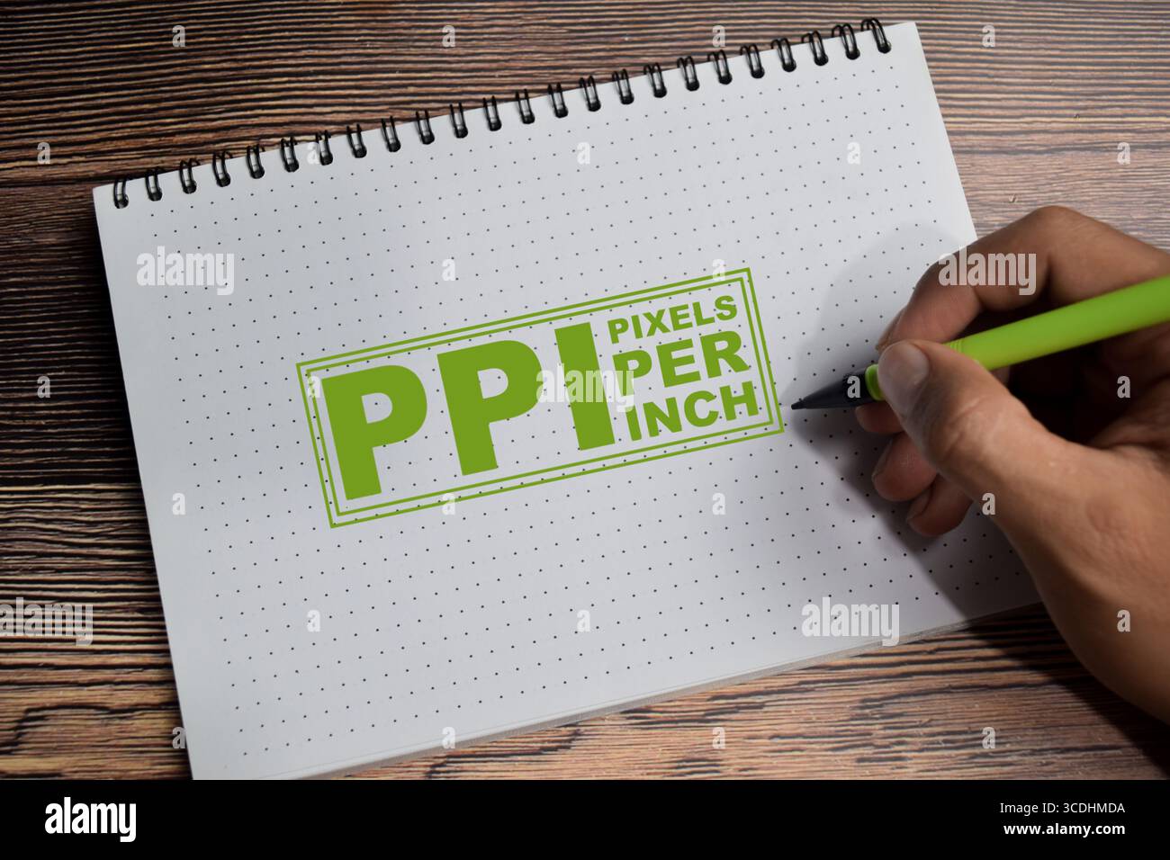 Konzept der PPI - Pixel pro Zoll sind Messungen der Pixeldichte, die auf einem Buch auf einem Holztisch geschrieben werden. Stockfoto