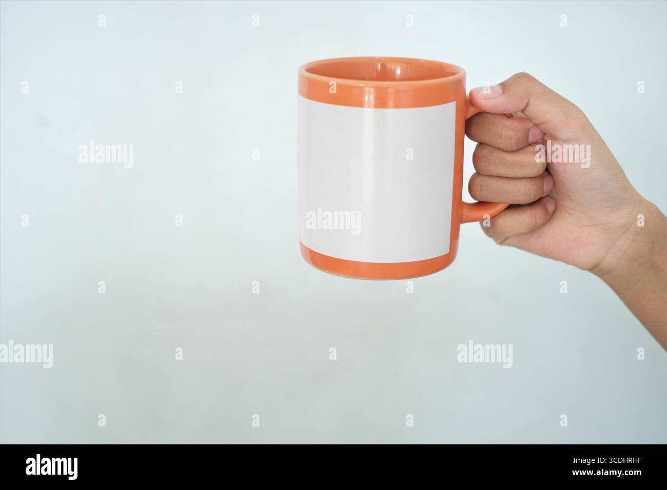 Hand hält einen sauberen isolierten Becher. Für Print-on-Demand-Design-Werbeaktion. Stockfoto