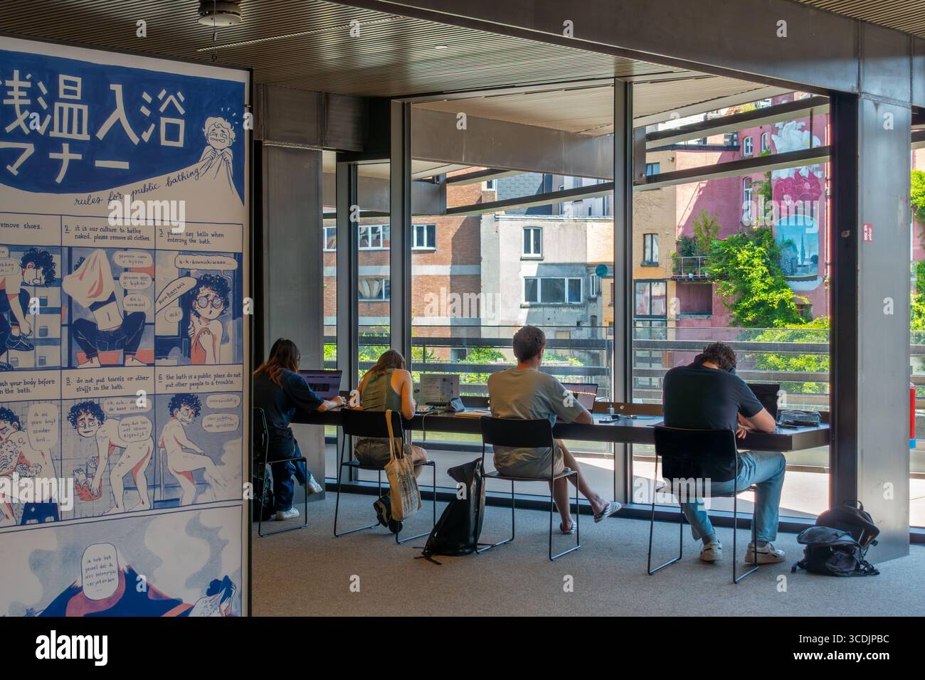 Universitätsstudenten mit Laptops, die in der öffentlichen Bibliothek de Krook für ihre erneute Prüfung während der Sommerferien in der Stadt Gent, Belgien, studieren Stockfoto