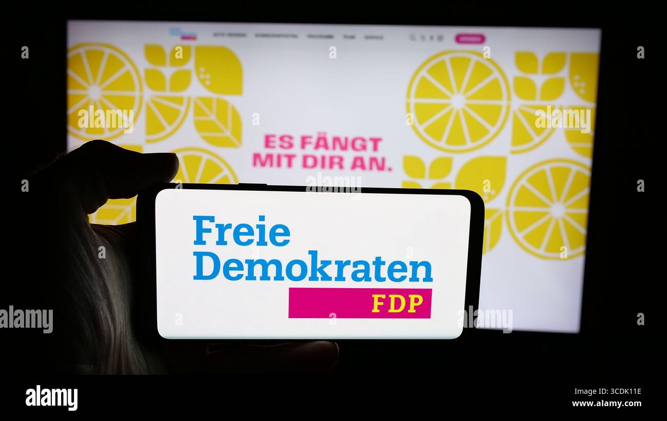 Stuttgart, Deutschland - 07-30-2025: Handybesitzer mit Logo der Freien Demokratischen Partei (FDP) auf dem Bildschirm vor der Webseite. Stockfoto