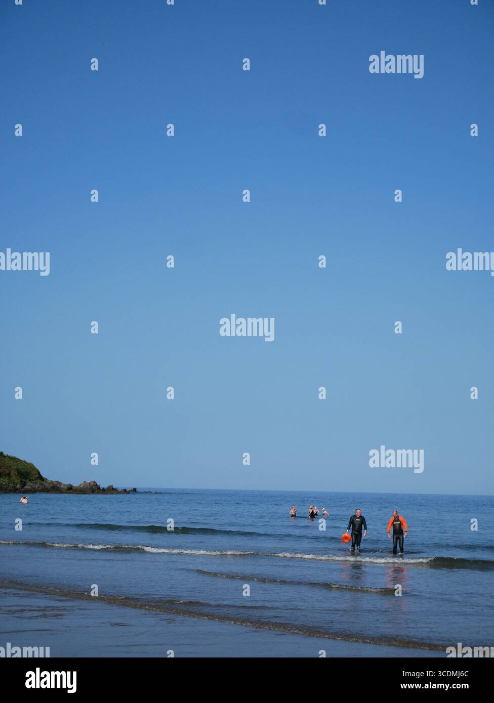 Am frühen Morgen laufen Meeresschwimmer zurück zum Strand, Bigbury on Sea, South Hams, Südküste von Devon, England, Großbritannien Stockfoto