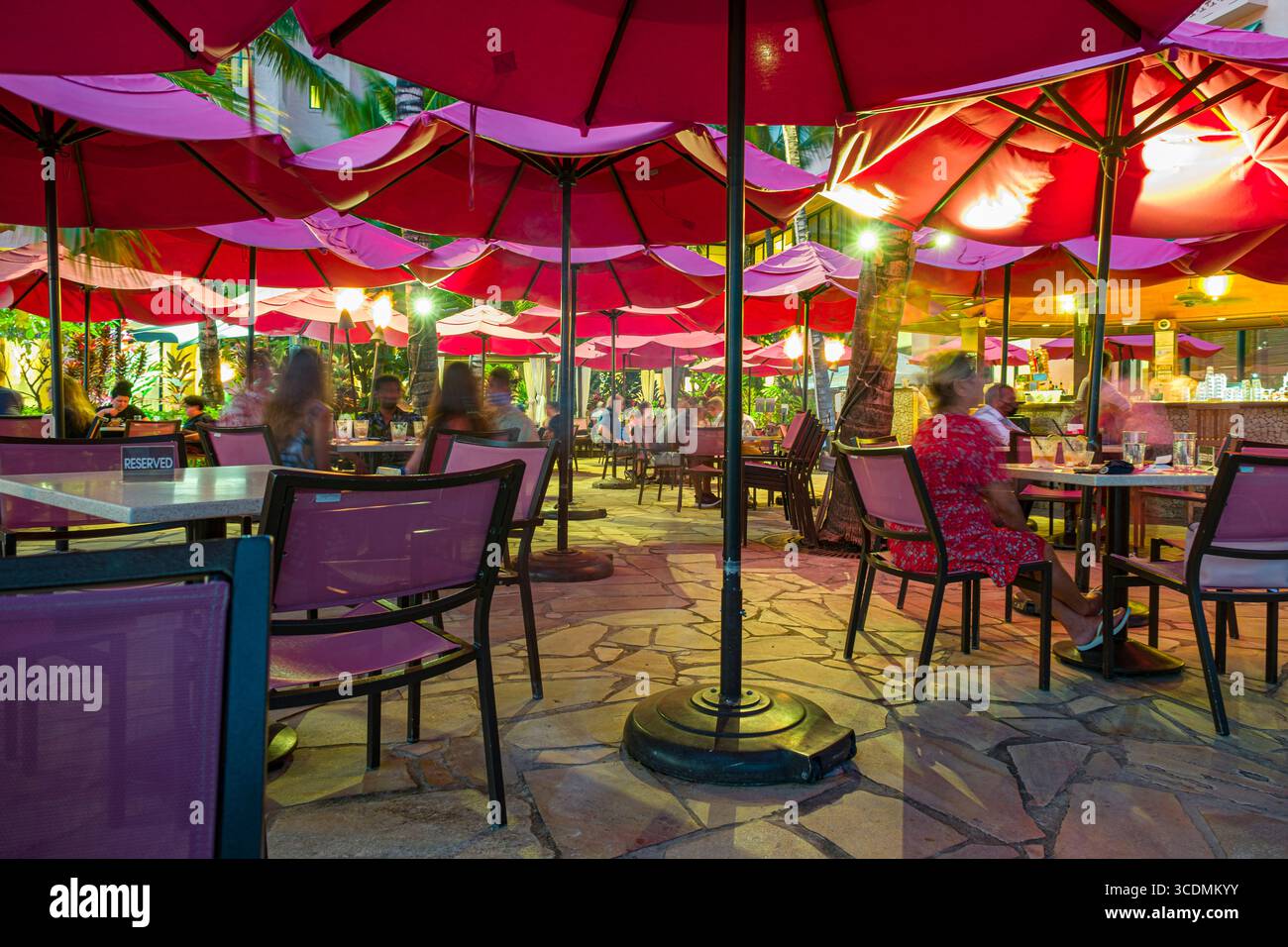 Essen im Freien unter pinken Sonnenschirmen in der Mai Tai Bar im Royal Hawaiian, A Luxury Collection Resort, Waikiki, Honolulu, Oahu, Hawaii, USA Stockfoto