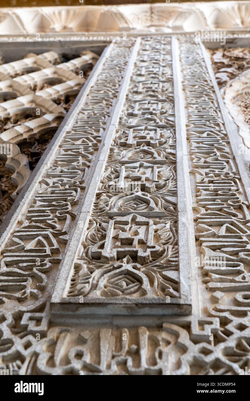 Komplizierte arabische Kalligraphie-Schnitzerei in andalusischem Architekturdetail Stockfoto Komplizierte arabische Kalligraphie-Schnitzerei in andalusischem Architekturdetail Stockfoto
