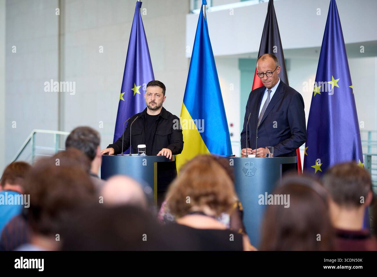 Berlin, Deutschland. August 2025. Der ukrainische Präsident Wolodymyr Zelenskyj, links, und der deutsche Bundeskanzler Friedrich Merz, rechts, hören eine Frage während einer gemeinsamen Pressekonferenz im Kanzleramt am 13. August 2025 in Berlin. Das Briefing folgte auf ein virtuelles Gipfeltreffen mit europäischen Staats- und Regierungschefs und US-Präsident Donald Trump. Quelle: Pool Photo/Ukrainische Präsidentenpresse/Alamy Live News Stockfoto