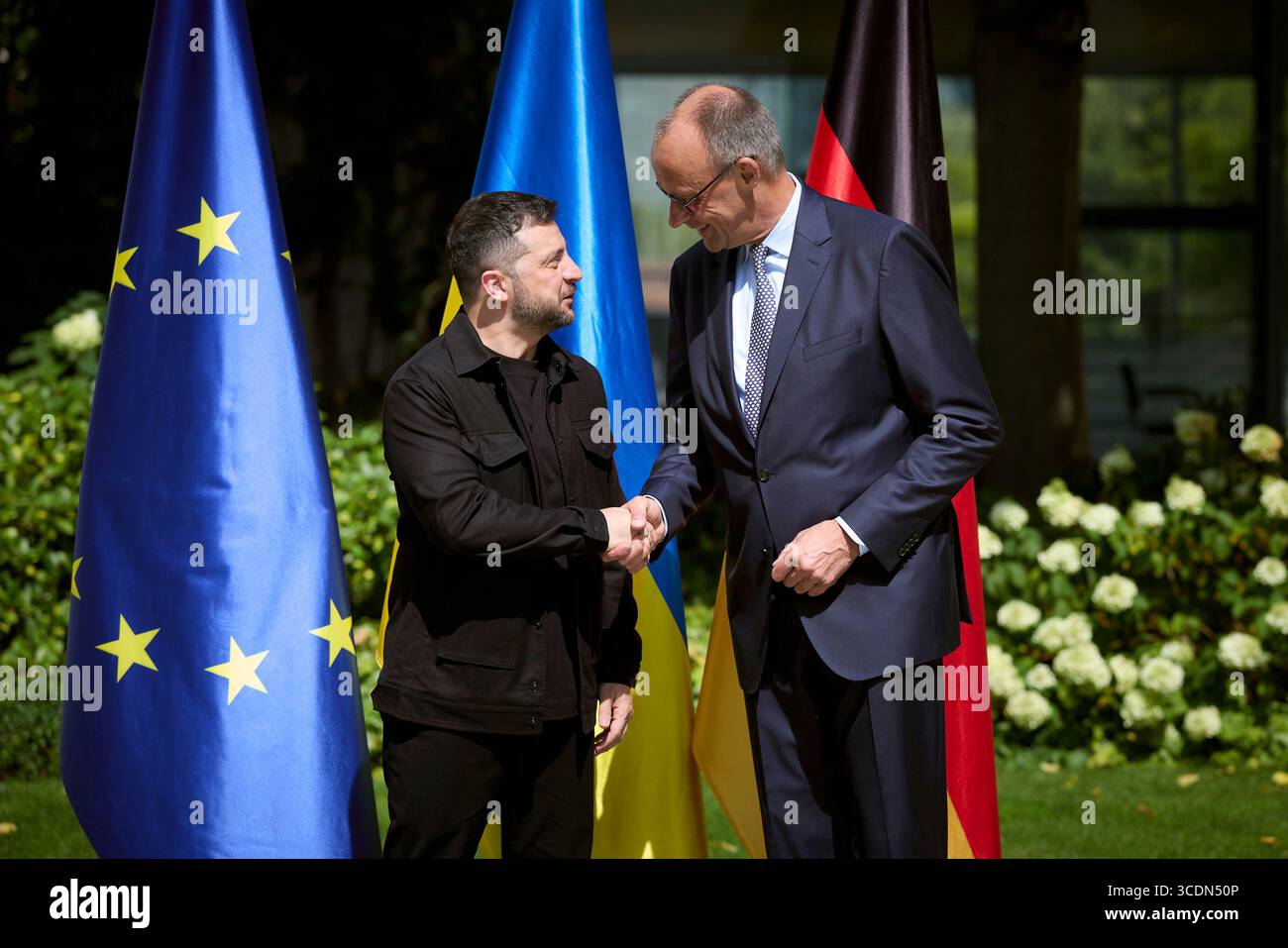 Berlin, Deutschland. August 2025. Der ukrainische Präsident Wolodymyr Zelenskyj, links, schüttelt bei der Ankunft im Bundeskanzleramt am 13. August 2025 in Berlin die Hand mit dem deutschen Bundeskanzler Friedrich Merz. Zelenskyy besucht ein virtuelles Gipfeltreffen mit europäischen Staats- und Regierungschefs und US-Präsident Donald Trump. Quelle: Pool Photo/Ukrainische Präsidentenpresse/Alamy Live News Stockfoto