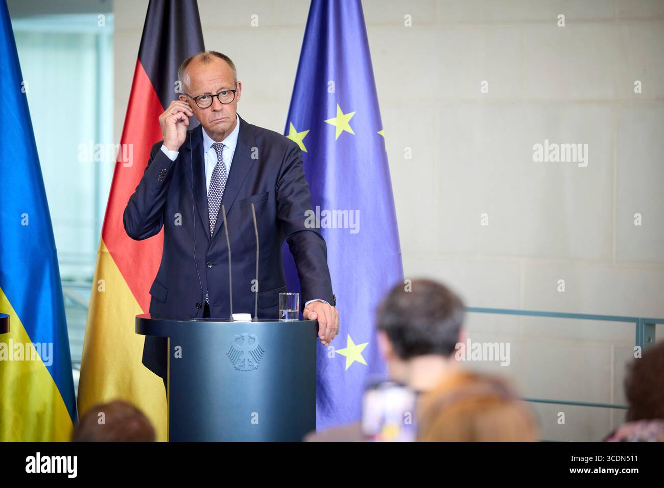 Berlin, Deutschland. August 2025. Bundeskanzler Friedrich Merz hört eine Frage während einer gemeinsamen Pressekonferenz mit dem ukrainischen Präsidenten Wolodymyr Zelenskyj im Kanzleramt am 13. August 2025 in Berlin. Das Briefing folgte auf ein virtuelles Gipfeltreffen mit europäischen Staats- und Regierungschefs und US-Präsident Donald Trump. Quelle: Pool Photo/Ukrainische Präsidentenpresse/Alamy Live News Stockfoto