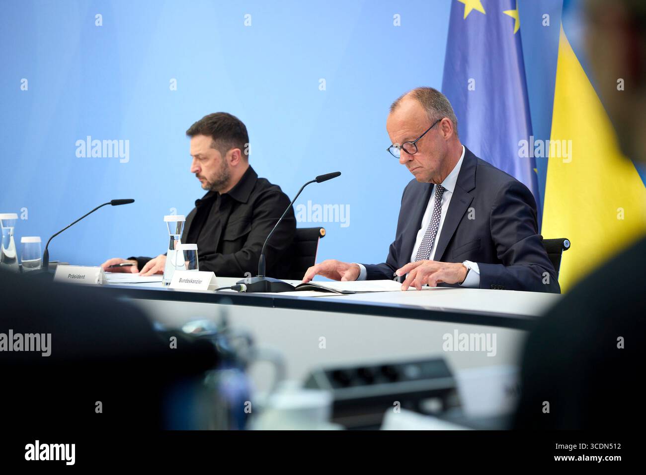 Berlin, Deutschland. August 2025. Der ukrainische Präsident Wolodymyr Zelenskyj, links, und der deutsche Bundeskanzler Friedrich Merz, rechts, hören auf einem virtuellen Gipfeltreffen im Kanzleramt am 13. August 2025 in Berlin zu. Die beiden Staats- und Regierungschefs veranstalteten ein virtuelles Gipfeltreffen mit europäischen Staats- und Regierungschefs und US-Präsident Donald Trump, um den bevorstehenden US-russischen Gipfel zu erörtern. Quelle: Pool Photo/Ukrainische Präsidentenpresse/Alamy Live News Stockfoto