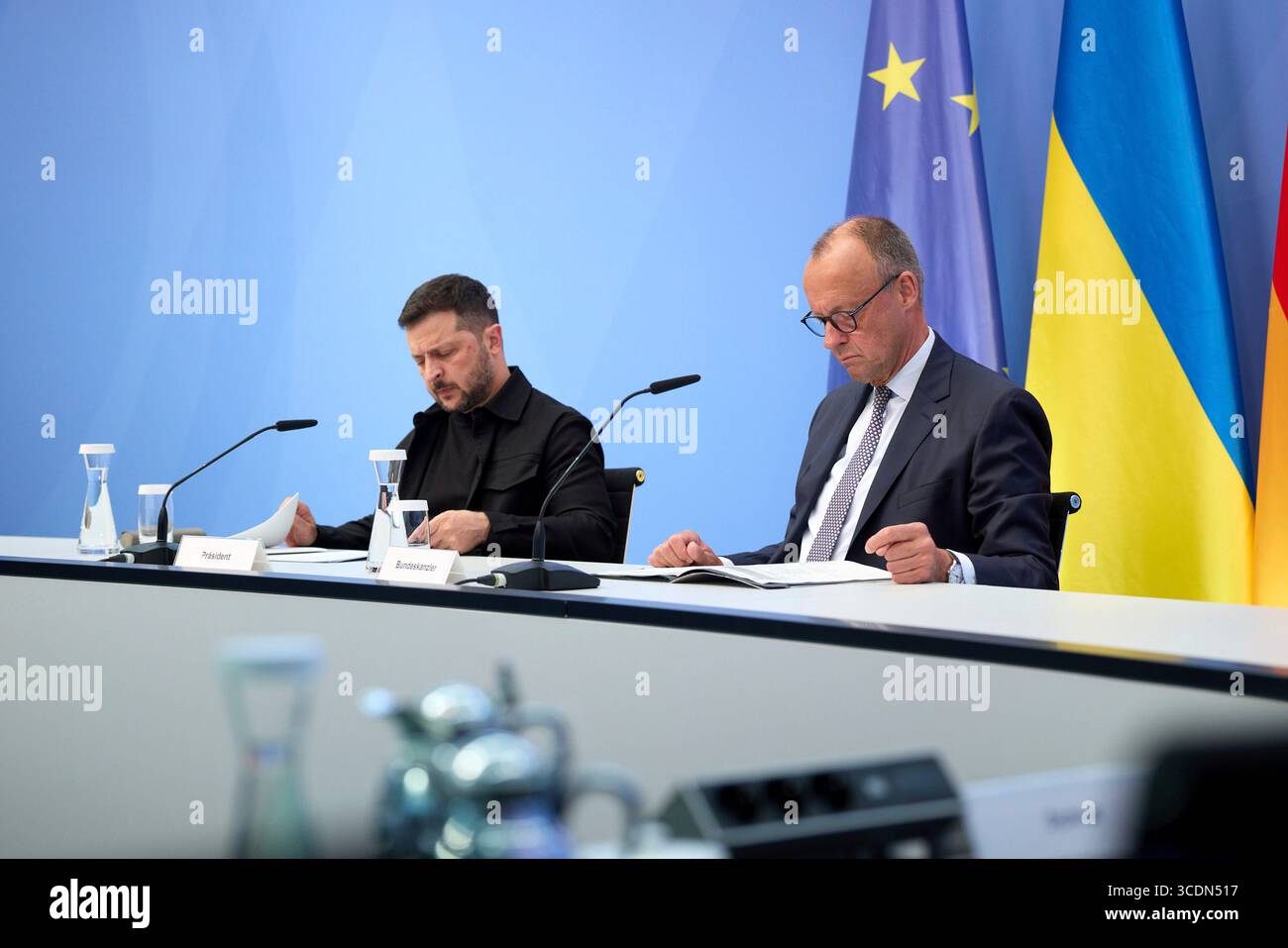 Berlin, Deutschland. August 2025. Der ukrainische Präsident Wolodymyr Zelenskyj, links, und der deutsche Bundeskanzler Friedrich Merz, rechts, hören auf einem virtuellen Gipfeltreffen im Kanzleramt am 13. August 2025 in Berlin zu. Die beiden Staats- und Regierungschefs veranstalteten ein virtuelles Gipfeltreffen mit europäischen Staats- und Regierungschefs und US-Präsident Donald Trump, um den bevorstehenden US-russischen Gipfel zu erörtern. Quelle: Pool Photo/Ukrainische Präsidentenpresse/Alamy Live News Stockfoto