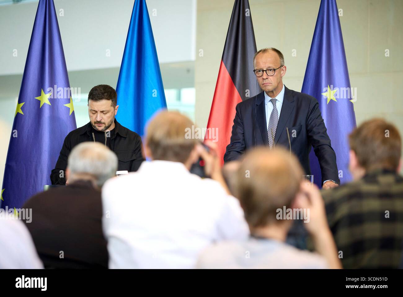 Berlin, Deutschland. August 2025. Der ukrainische Präsident Wolodymyr Zelenskyj, links, und der deutsche Bundeskanzler Friedrich Merz, rechts, hören eine Frage während einer gemeinsamen Pressekonferenz im Kanzleramt am 13. August 2025 in Berlin. Das Briefing folgte auf ein virtuelles Gipfeltreffen mit europäischen Staats- und Regierungschefs und US-Präsident Donald Trump. Quelle: Pool Photo/Ukrainische Präsidentenpresse/Alamy Live News Stockfoto