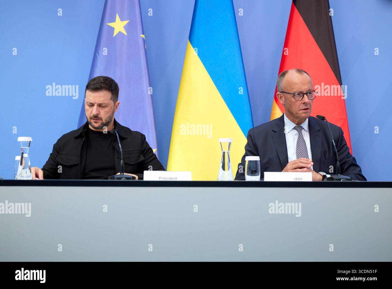 Berlin, Deutschland. August 2025. Der ukrainische Präsident Wolodymyr Zelenskyj, links, und der deutsche Bundeskanzler Friedrich Merz, rechts, hören auf einem virtuellen Gipfeltreffen im Kanzleramt am 13. August 2025 in Berlin zu. Die beiden Staats- und Regierungschefs veranstalteten ein virtuelles Gipfeltreffen mit europäischen Staats- und Regierungschefs und US-Präsident Donald Trump, um den bevorstehenden US-russischen Gipfel zu erörtern. Quelle: Pool Photo/Ukrainische Präsidentenpresse/Alamy Live News Stockfoto