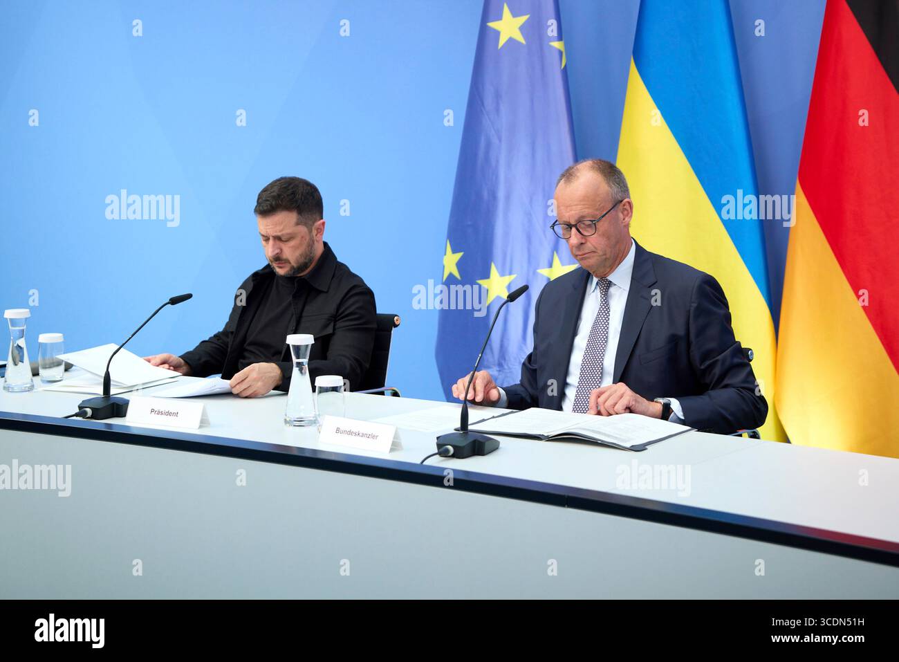 Berlin, Deutschland. August 2025. Der ukrainische Präsident Wolodymyr Zelenskyj, links, und der deutsche Bundeskanzler Friedrich Merz, rechts, hören auf einem virtuellen Gipfeltreffen im Kanzleramt am 13. August 2025 in Berlin zu. Die beiden Staats- und Regierungschefs veranstalteten ein virtuelles Gipfeltreffen mit europäischen Staats- und Regierungschefs und US-Präsident Donald Trump, um den bevorstehenden US-russischen Gipfel zu erörtern. Quelle: Pool Photo/Ukrainische Präsidentenpresse/Alamy Live News Stockfoto