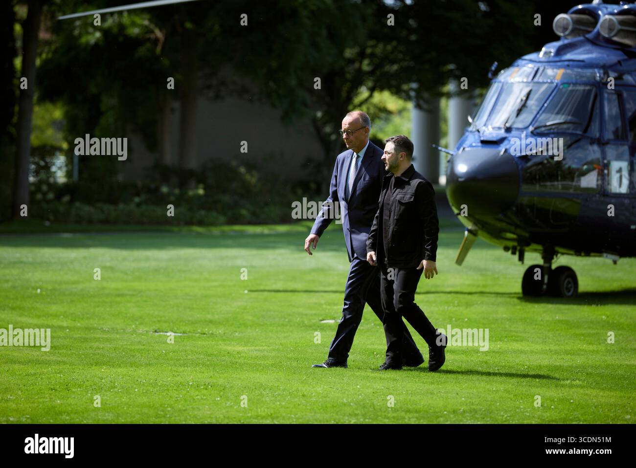Berlin, Deutschland. August 2025. Der ukrainische Präsident Wolodymyr Zelenskyj, rechts, wird von Bundeskanzler Friedrich Merz, links, bei der Ankunft mit dem Hubschrauber zum Bundeskanzleramt am 13. August 2025 in Berlin begleitet. Zelenskyy besucht ein virtuelles Gipfeltreffen mit europäischen Staats- und Regierungschefs und US-Präsident Donald Trump. Quelle: Pool Photo/Ukrainische Präsidentenpresse/Alamy Live News Stockfoto