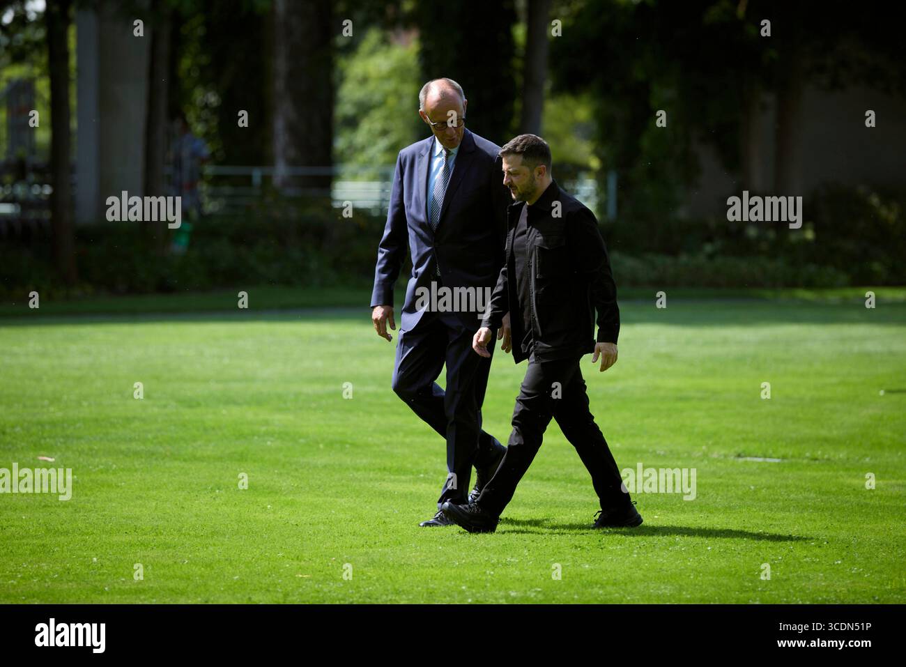 Berlin, Deutschland. August 2025. Der ukrainische Präsident Wolodymyr Zelenskyj, rechts, wird von Bundeskanzler Friedrich Merz, links, bei der Ankunft mit dem Hubschrauber zum Bundeskanzleramt am 13. August 2025 in Berlin begleitet. Zelenskyy besucht ein virtuelles Gipfeltreffen mit europäischen Staats- und Regierungschefs und US-Präsident Donald Trump. Quelle: Pool Photo/Ukrainische Präsidentenpresse/Alamy Live News Stockfoto