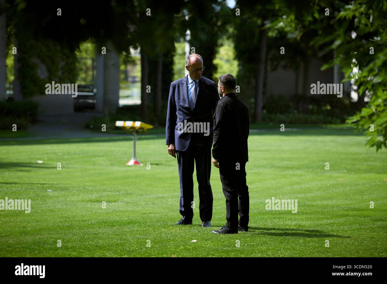 Berlin, Deutschland. August 2025. Der ukrainische Präsident Wolodymyr Zelenskyj, rechts, wird von Bundeskanzler Friedrich Merz, links, bei der Ankunft mit dem Hubschrauber zum Bundeskanzleramt am 13. August 2025 in Berlin begleitet. Zelenskyy besucht ein virtuelles Gipfeltreffen mit europäischen Staats- und Regierungschefs und US-Präsident Donald Trump. Quelle: Pool Photo/Ukrainische Präsidentenpresse/Alamy Live News Stockfoto