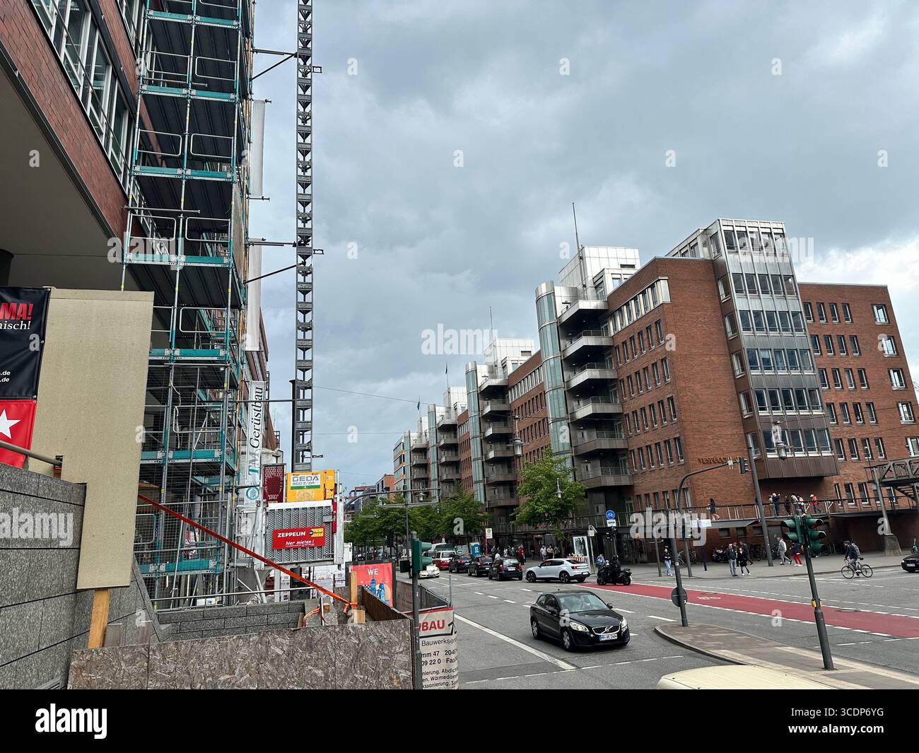 Urbane Straßenszene mit Baugerüsten und modernen Bürogebäuden in Hamburg, Deutschland, unter bewölktem Himmel.Hamburg Deutschland, urbanes Bauen - Smartphone-aufgenommenes Stockfoto