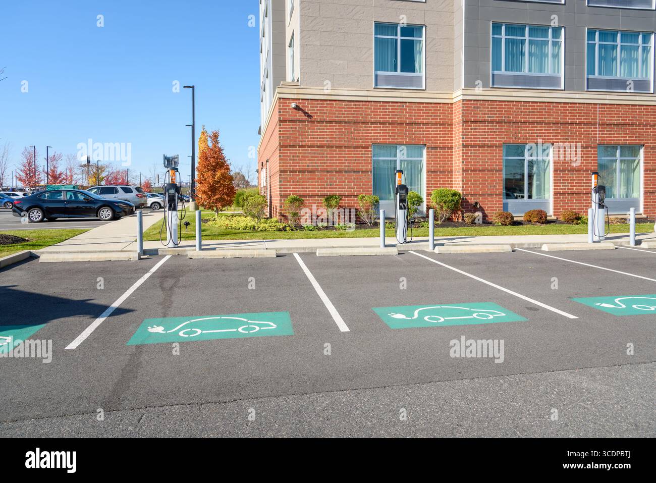 Verlassene Ladestationen für Elektroautos auf einem öffentlichen Parkplatz an einem sonnigen Herbstmorgen Stockfoto