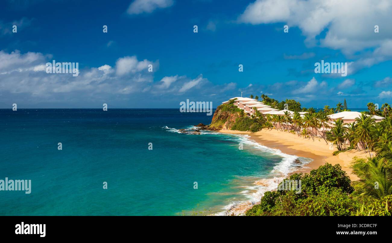 Tiefblauer Himmel über ruhigem goldenem Sand und azurblauem Meer am Valley Church Beach, Antigua Stockfoto