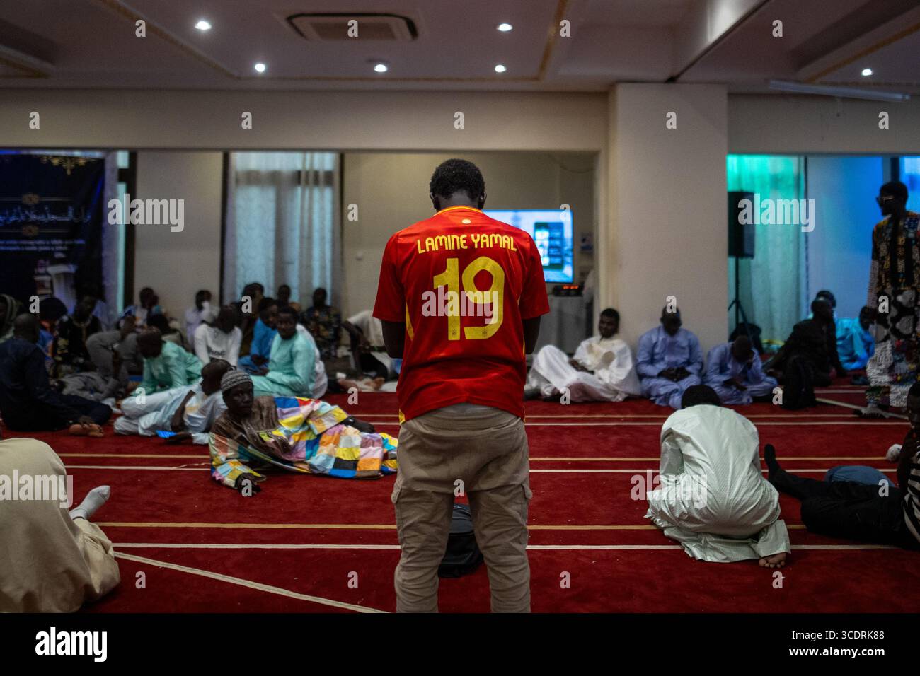 Madrid, Spanien. August 2025. Ein Mann in einem spanischen Nationalmannschaftstrikot mit der Nummer 19 von Lamine Yamal betet. Das große Magal von Touba ist das wichtigste religiöse fest der Mourid Brutherhood im Senegal, einem Zweig des Sufi Islam. Es wird jährlich in der Stadt Touba gefeiert, um dem Leben und den Lehren seines Gründers Cheikh Ahmadou Bamba zu gedenken. (Foto: David Canales/SOPA Images/SIPA USA) Credit: SIPA USA/Alamy Live News Stockfoto