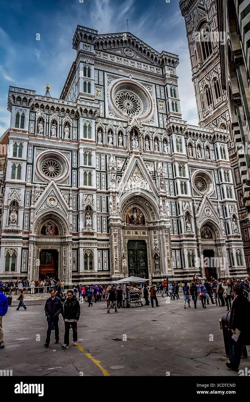 Kathedrale der Heiligen Maria von der Blume - die Kathedrale der katholischen Erzdiözese Florenz in Florenz, Italien. Die Basilika wurde 1296 im gotischen Stil nach einem Entwurf Arnolfo di Cambio begonnen und 1436 mit einer von Filippo Brunelleschi erarbeiteten Kuppel fertiggestellt. Das Äußere der Basilika ist mit polychromen Marmorpaneelen in verschiedenen Grün- und Rosa-Tönen, abwechselnd weiß, überzogen und weist eine aufwendige Westfassade aus dem 19. Jahrhundert im gotischen Stil von Emilio de Fabris auf. Stockfoto