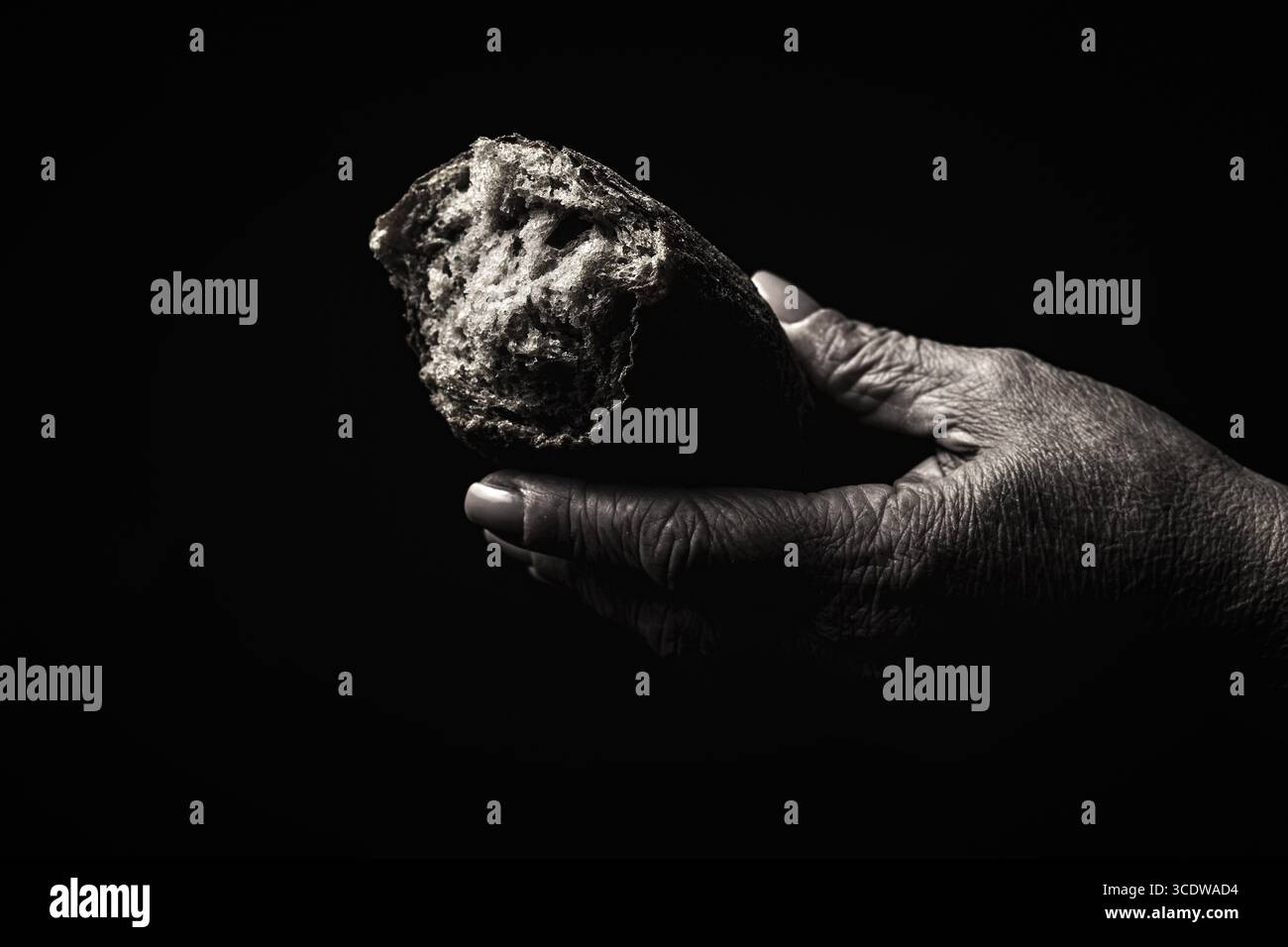 Mann gibt Brot, helft Hand. Männliche Hände mit einem Stück Brot, Armut, Hunger. Frauenhände brechen ein Stück frisches Brot ab. Unterstützung bei der Hand-Freigabe Stockfoto