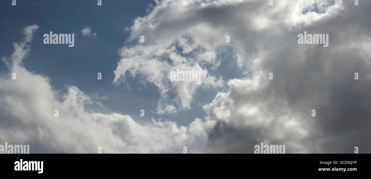 Wirbel aus weißen Wolken gegen einen blauen Himmel Stockfoto