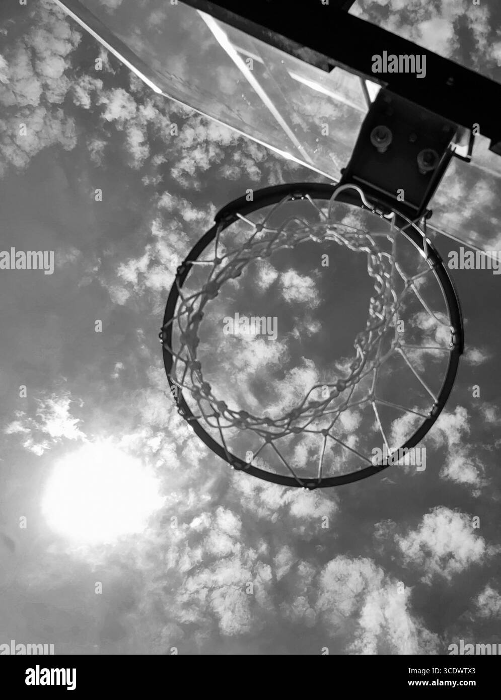 Solar Slam Dunk – abstrakte Basketball-Hoop- und Sonnenperspektive. Einfarbige Farbtöne. Stockfoto