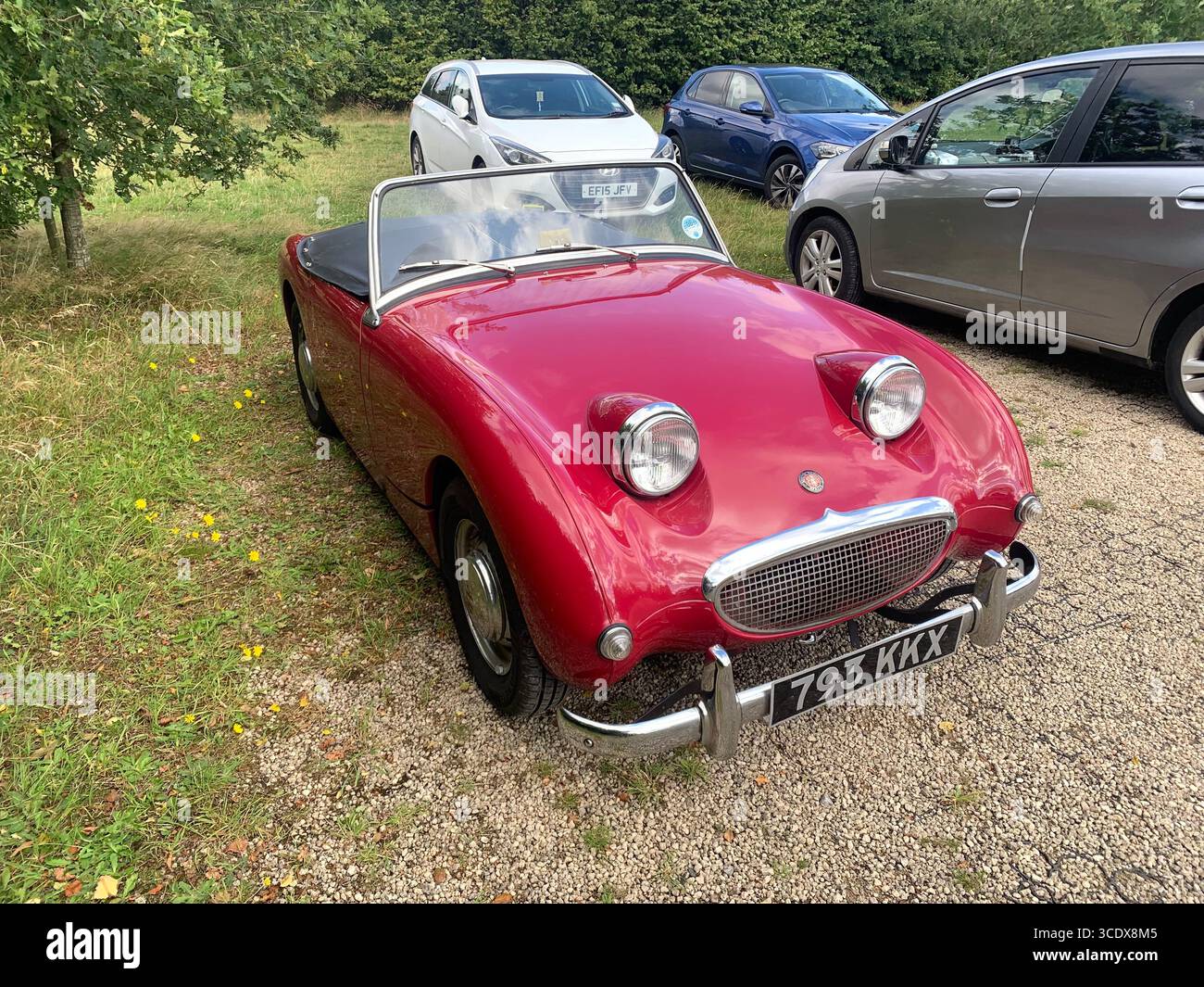 Austin Healey Sprite Cabriolet alter Stil 1959 britisches sportliches Fahrzeug rot hübsches Aussehen Oldtimer Scheinwerfer großes Design UK - Smartphone-aufgenommenes Stockfoto