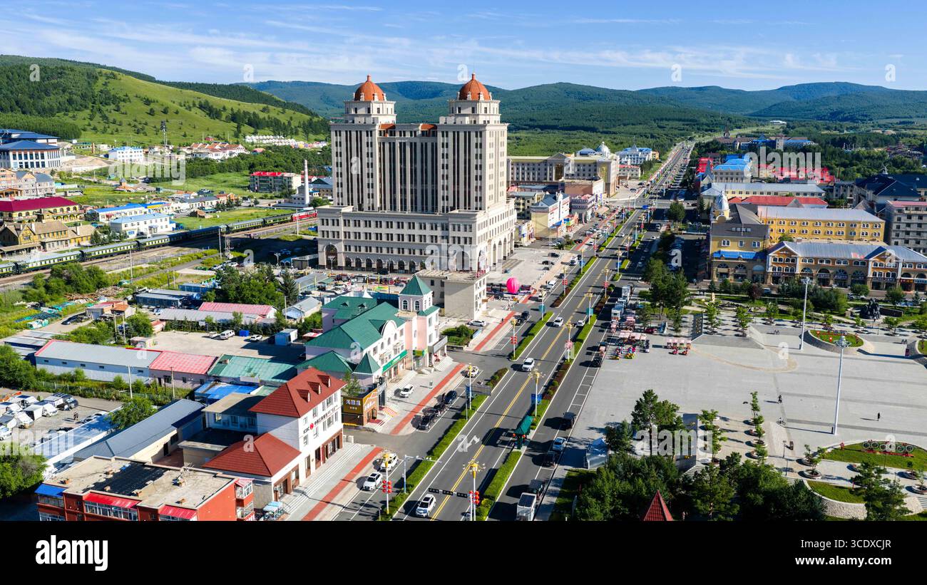 Hohhot. Juli 2025. Eine Luftdrohne, die am 27. Juli 2025 aufgenommen wurde, zeigt die Hauptstraße in Arxan, der autonomen Region Innere Mongolei im Norden Chinas. Arxan, eine Stadt mit weniger als 40.000 Einwohnern und einer Vegetationsfläche von über 95 Prozent, liegt am südwestlichen Fuß des Dahinggan-Gebirges, dem Schnittpunkt von vier großen Graslandschaften in Nordchina. Heute ist es ein immer beliebter werdendes Reiseziel. Quelle: Ma Jinrui/Xinhua/Alamy Live News Stockfoto