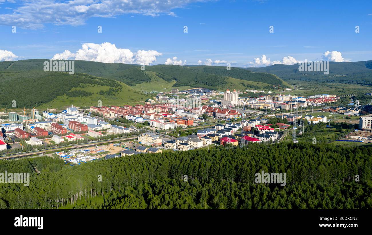 Hohhot. Juli 2025. Ein Luftbild der Drohne, aufgenommen am 27. Juli 2025, zeigt die Stadtansicht in Arxan, der autonomen Region Innere Mongolei im Norden Chinas. Arxan, eine Stadt mit weniger als 40.000 Einwohnern und einer Vegetationsfläche von über 95 Prozent, liegt am südwestlichen Fuß des Dahinggan-Gebirges, dem Schnittpunkt von vier großen Graslandschaften in Nordchina. Heute ist es ein immer beliebter werdendes Reiseziel. Quelle: Ma Jinrui/Xinhua/Alamy Live News Stockfoto